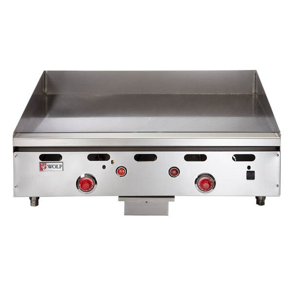 A Wolf stainless steel liquid propane griddle with red knobs on a counter.