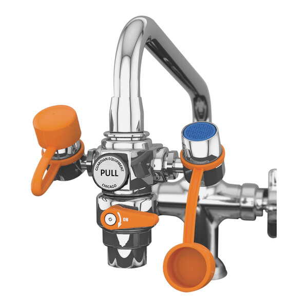 A Guardian eyewash station faucet with orange and blue handles.