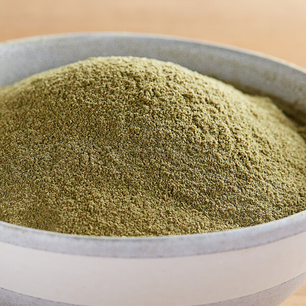 A bowl of Regal Ground Marjoram powder on a wooden table.