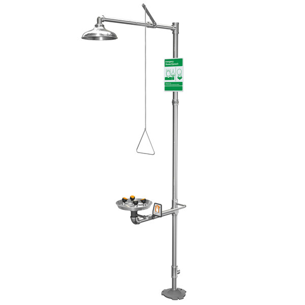 A Guardian Equipment barrier-free safety station with a green and white sign above a shower stand.