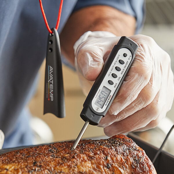 A person using an AvaTemp digital pocket probe thermometer to check the temperature of meat.