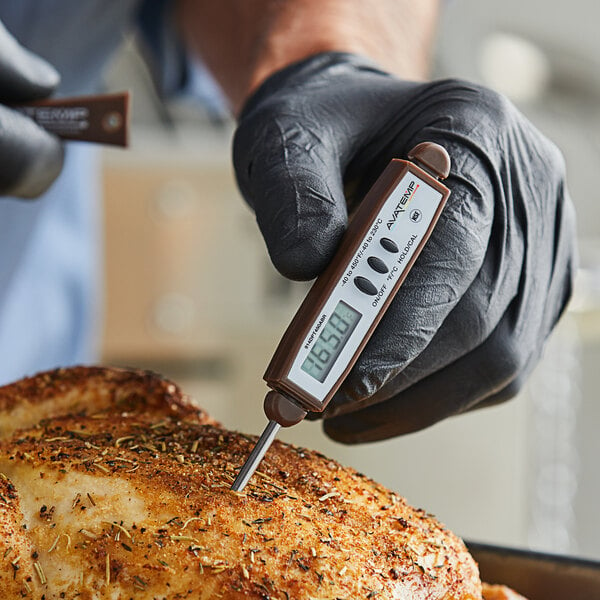 A person in gloves using an AvaTemp 2 digital pocket probe thermometer to measure the temperature of cooked meat.