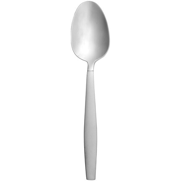 A white tube with a white cap containing a silver Delco Colton dinner spoon with a white handle.