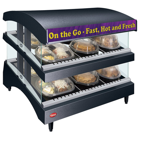A Hatco countertop food warmer with food trays in a display case.
