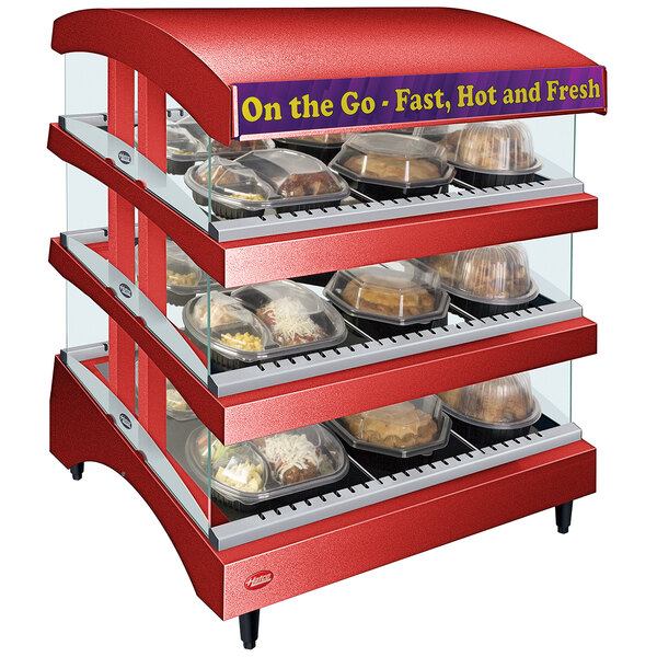 A red Hatco countertop hot food display case with trays of food.