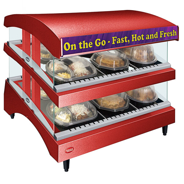A red Hatco countertop food display case with heated shelves holding food.