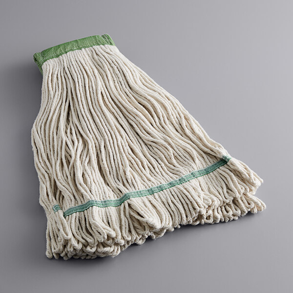 A white cotton wet mop with green trim on a gray surface.
