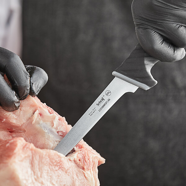 A person in black gloves using a Schraf narrow boning knife to cut meat.
