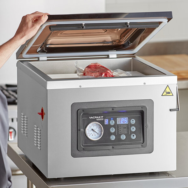 A person using a VacPak-It chamber vacuum machine to seal meat.