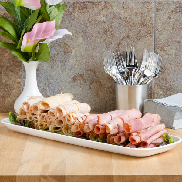 A Sabert white rectangular catering tray with meat and vegetables on it.