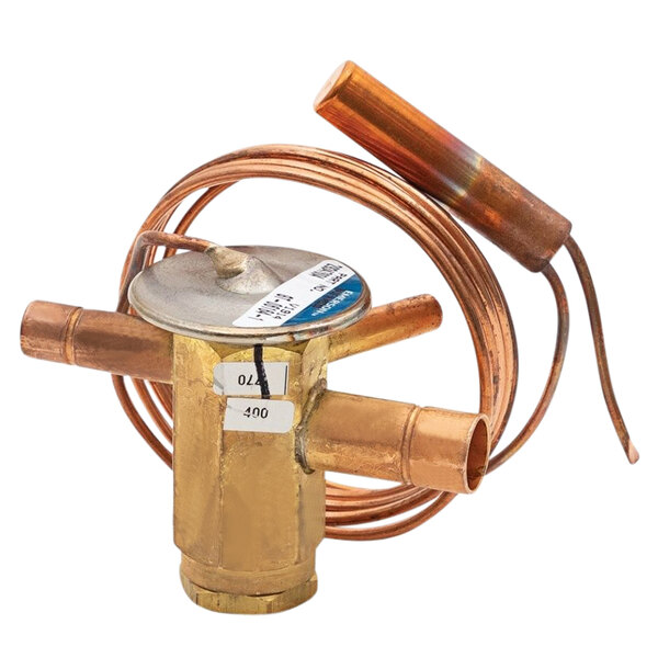 A copper Heatcraft TXV valve with a round cap on a copper pipe.