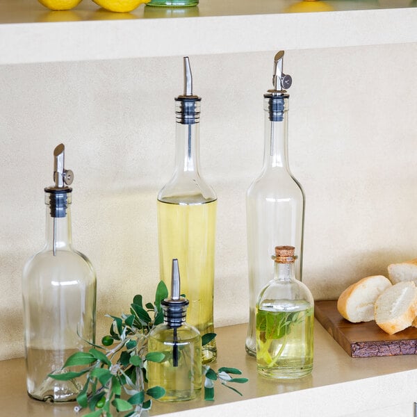 A shelf with Tablecraft oil and vinegar bottles next to bread.