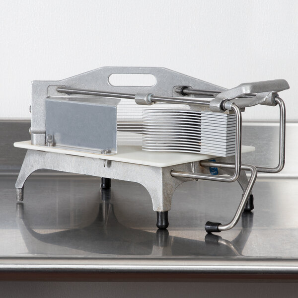 A Vollrath Redco Tomato Pro tomato slicer with a safety guard on a table.