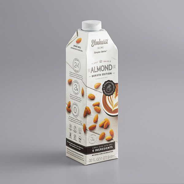 A case of 6 cartons of Elmhurst Barista Almond Milk on a gray surface.