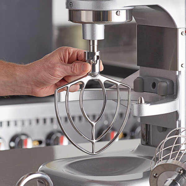 A hand using an Estella flat beater attachment on an Estella mixer.