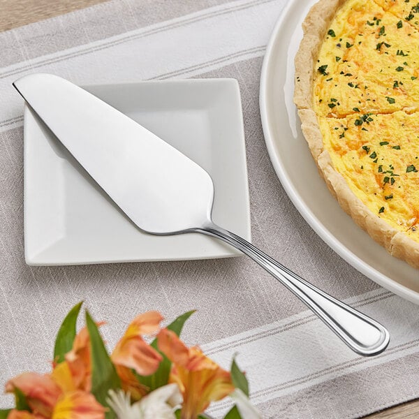 An Acopa Edgeworth stainless steel cake server on a plate with a pie