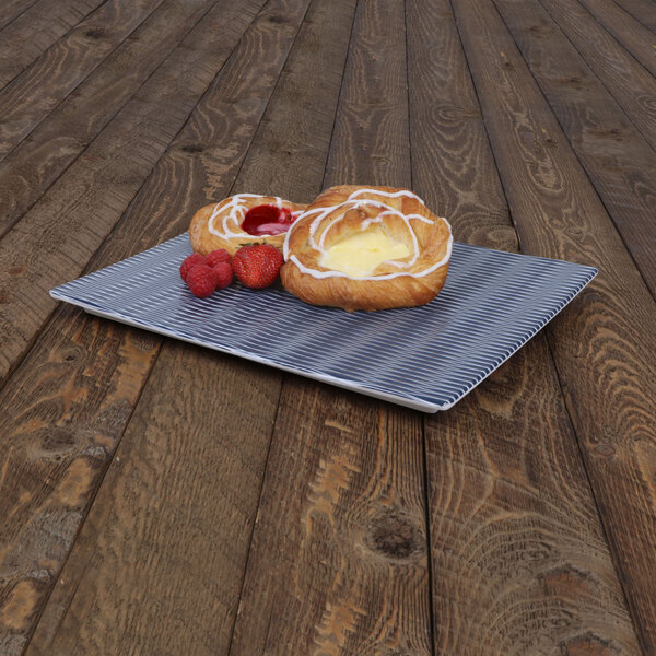 An Elite Global Solutions blue textured melamine platter with pastries and strawberries on a wood surface.