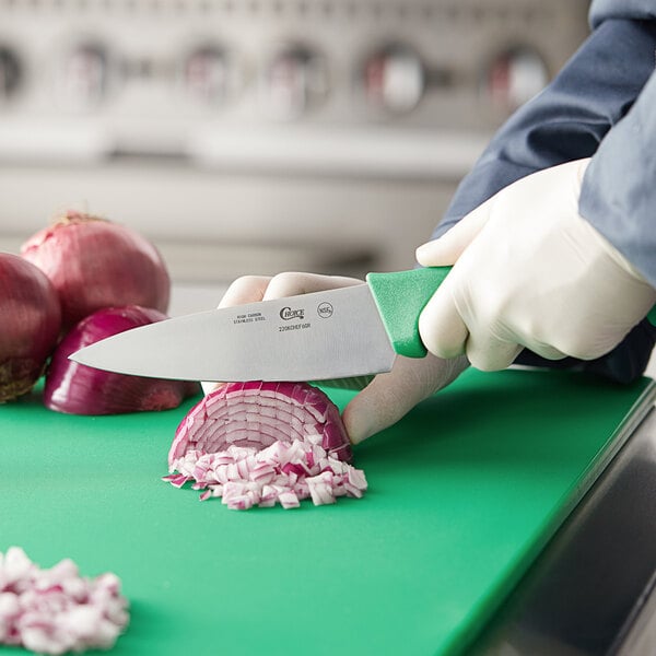 A person using a Choice chef knife to cut onions on a cutting board.