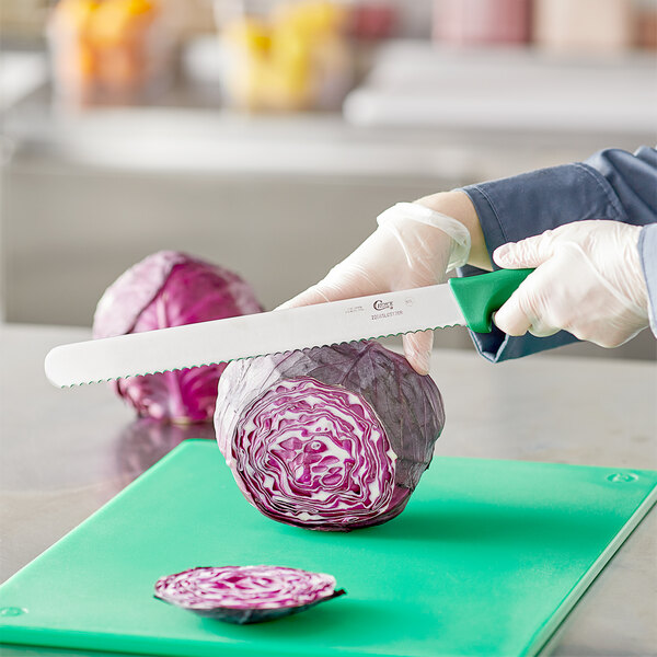 A person using a Choice serrated bread knife to cut cabbage.