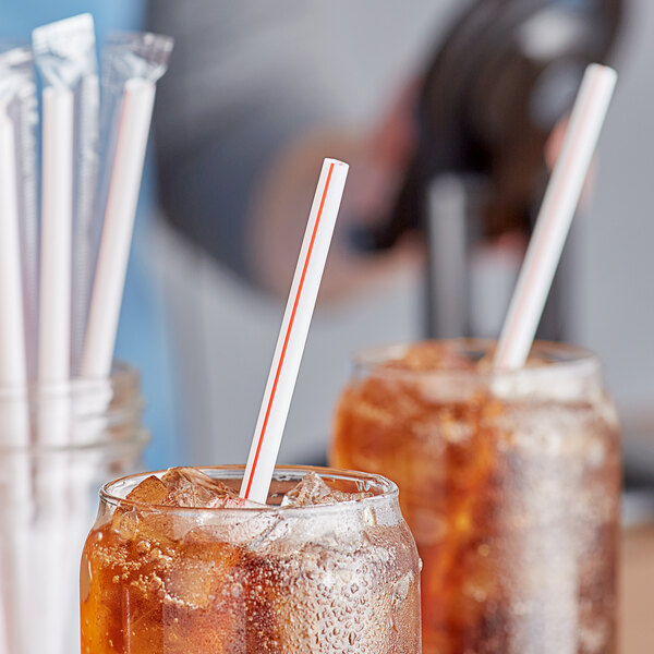 A close-up of a glass of iced tea with a Choice jumbo wrapped straw.