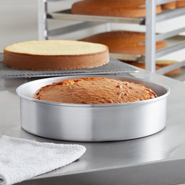 A round metal cake pan with a cake inside.