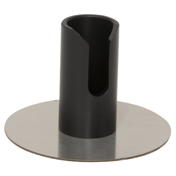 A black metal cylinder with a hole on a round metal surface.