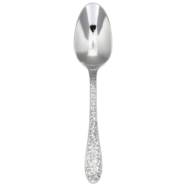 A close-up of a Oneida Ivy Flourish stainless steel teaspoon with a pattern on the handle.