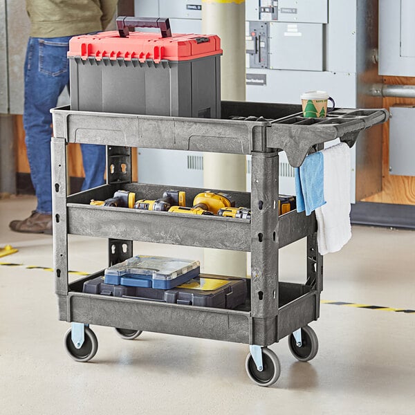 A man using a Lavex medium gray utility cart with tools.