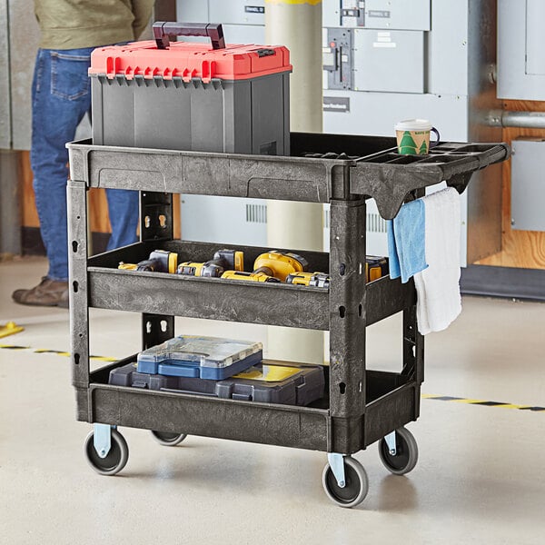 A man stands next to a black Lavex utility cart with shelves and tool compartments.