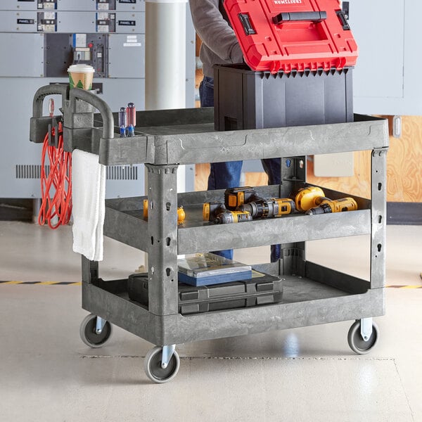 A man using a Lavex utility cart with built-in tool compartments to hold tools.
