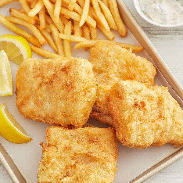 A plate of Golden Dipt English Style fish and chips with a lemon wedge.