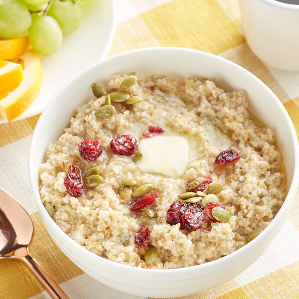 A bowl of Quaker steel cut oatmeal with dried cranberries and fruit on top.