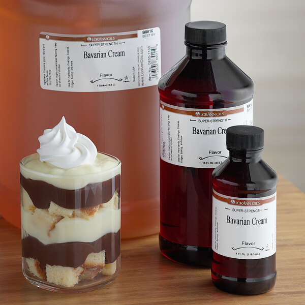 A dessert in a glass with whipped cream flavored with LorAnn Oils Bavarian Cream in front of a bottle.