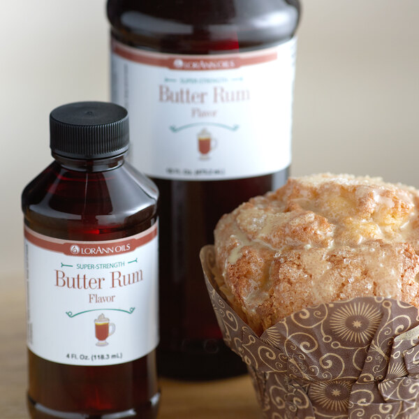 A muffin next to a bottle of LorAnn Oils Butter Rum flavor.