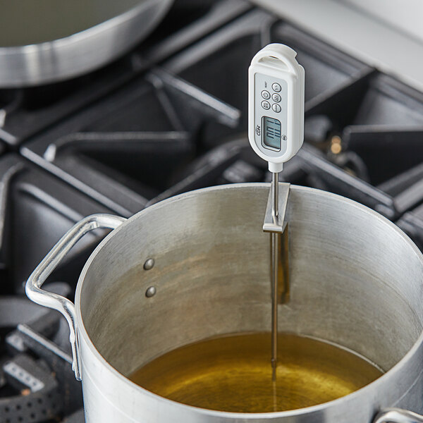 A CDN ProAccurate digital pocket probe thermometer inserted into a metal pot of liquid.