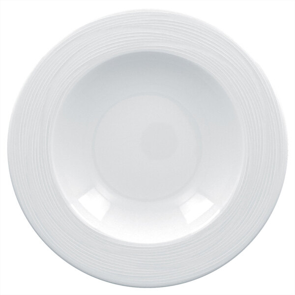 A close-up of a RAK Porcelain bright white porcelain plate with a wide rim and embossed spiral lines.