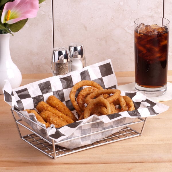 A chrome rectangular basket filled with fried food and a glass of soda.