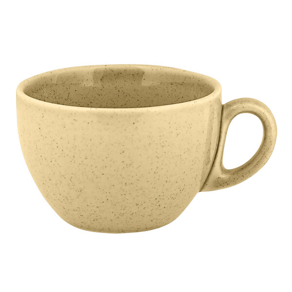 A close up of a beige RAK Porcelain coffee cup with a handle.