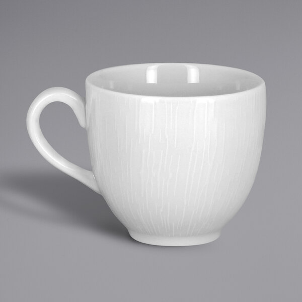 A close-up of a RAK Porcelain bright white cup with an embossed design and a handle.