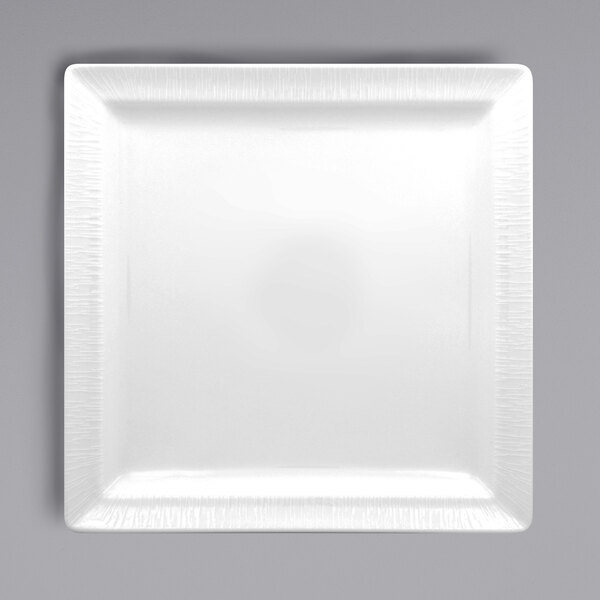 A white square porcelain plate with an embossed textured border.