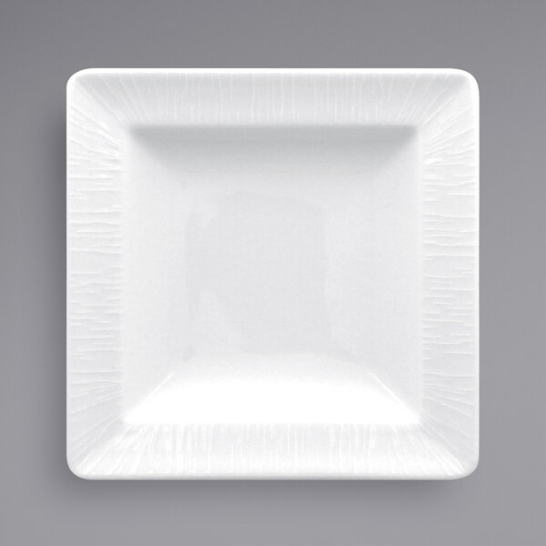 A white square RAK Porcelain plate with a textured pattern and white rim.