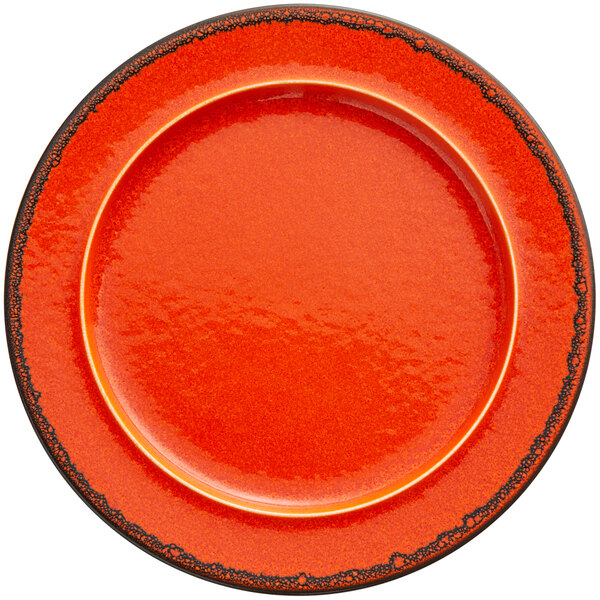 An orange RAK Porcelain plate with a black rim.
