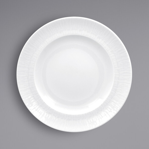 A close-up of a RAK Porcelain bright white plate with a textured white rim.