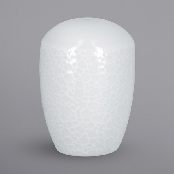A close-up of a white RAK Porcelain pepper shaker with an embossed pattern.