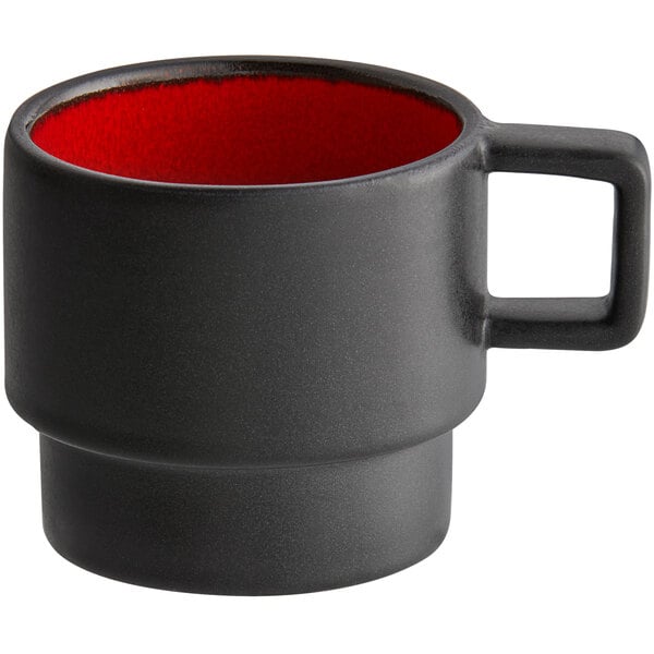 A black espresso cup with a red rim.