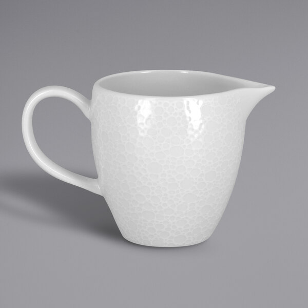 A RAK Porcelain white embossed porcelain creamer with a handle.