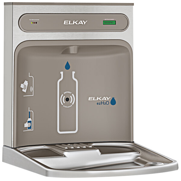 An Elkay light gray water bottle filling station on a counter with a bottle.