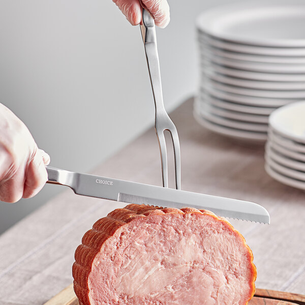 A person using a Choice stainless steel knife to cut meat on a plate.