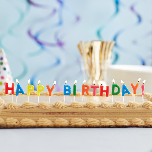A close-up of a birthday cake with Creative Converting Happy Birthday candle picks.