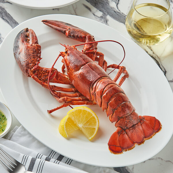 A Boston Lobster Company lobster on a white plate with a lemon wedge.